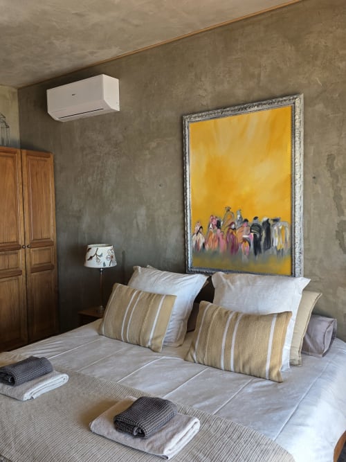 Quarto em Les Terrasses Les Suites em Calheta com vista para o mar, arte amarela, almofadas listradas e moderno ar condicionado branco