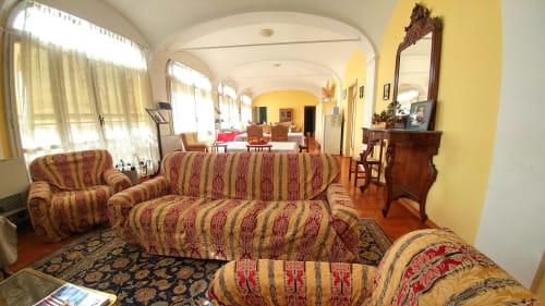 Elegante soggiorno del B&B Bresbot a Bressana con divani rigati, pareti gialle e soffitto ad arco