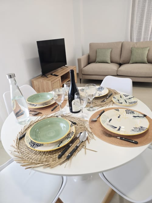 Elegante comedor del Apartamento Miramar en Gandía con mesa servida y vino