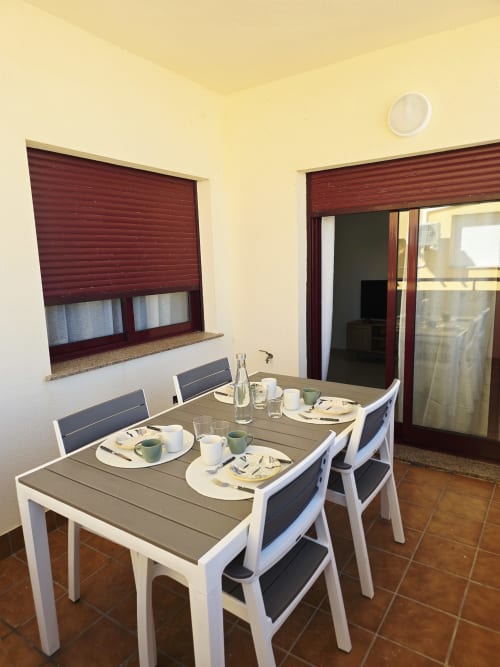 Comedor del Apartamento Miramar en Ona vacaciones, Gandía con mesa, sillas y ventana con vistas al jardín