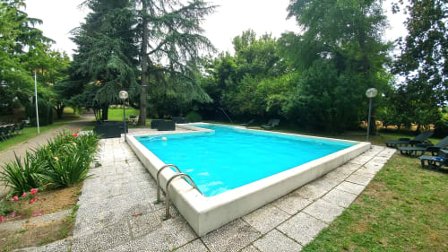 Piscina del Bresbot B&B a Bressana con acqua turchese, circondata da vegetazione lussureggiante e zona patio