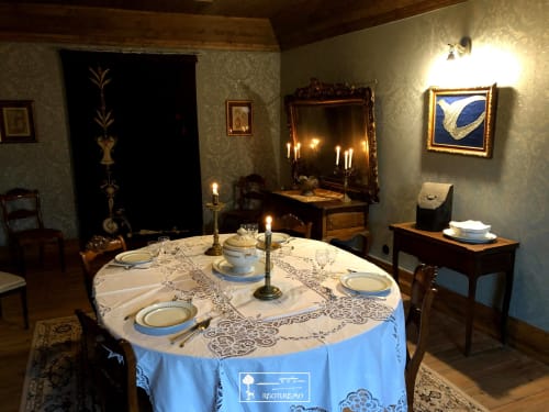 Elegant dining room at RISOTURISMO with candlelit round table, period furniture, and traditional Portuguese decor