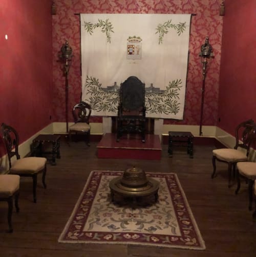 Historic parlor at Quinta das Pias with period furniture, ornate tapestry, and decorative brazier in Portuguese manor setting