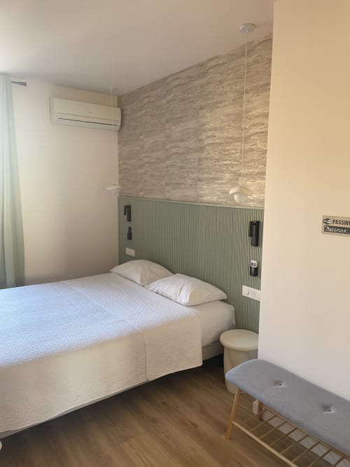 Chambre moderne aux Paquebots à Port-Vendres : lit, climatisation, mur texturé et parquet