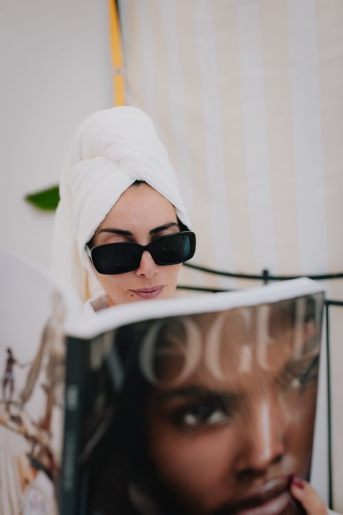 Mulher com toalha branca e óculos de sol na boutique hotel Herdade da Cova da Onça em Canha, Portugal