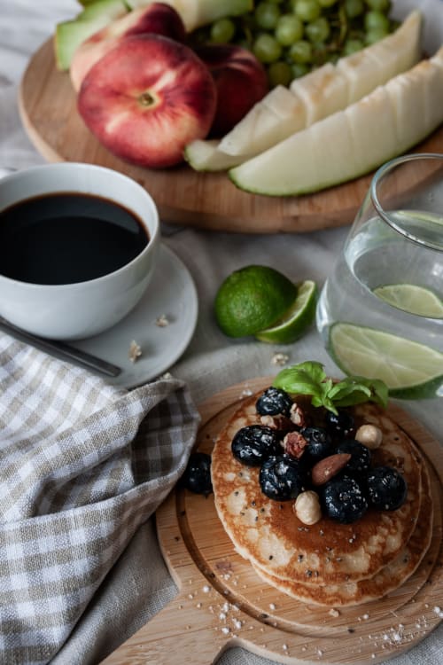 Mesa de café da manhã na Herdade da Cova da Onça com panquecas, frutas vermelhas, café e água com lima