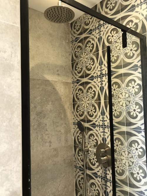 Salle de bains moderne avec douche à effet pluie et carreaux à motifs décoratifs à la villa La Conciergerie du Cap Corse