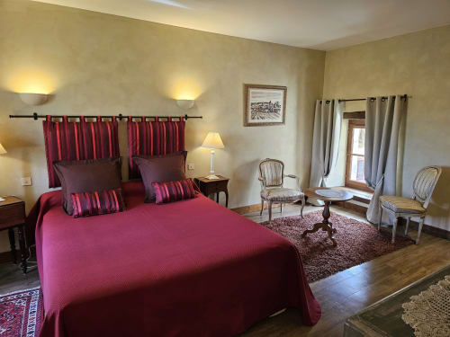 Chambre élégante du Château de Ribourdin avec lit bourgogne, tête de lit rayée et coin salon à Chevannes