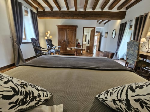 Chambre spacieuse aux poutres apparentes du Château de Ribourdin, avec lit king-size et vue sur le château à Chevannes