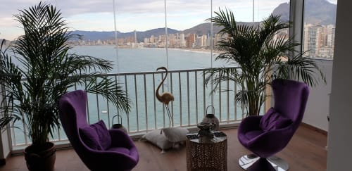 Lujosa zona de descanso en Portofino Playa con sillas moradas, plantas de palmera y vistas al mar Mediterráneo costera de Benidorm