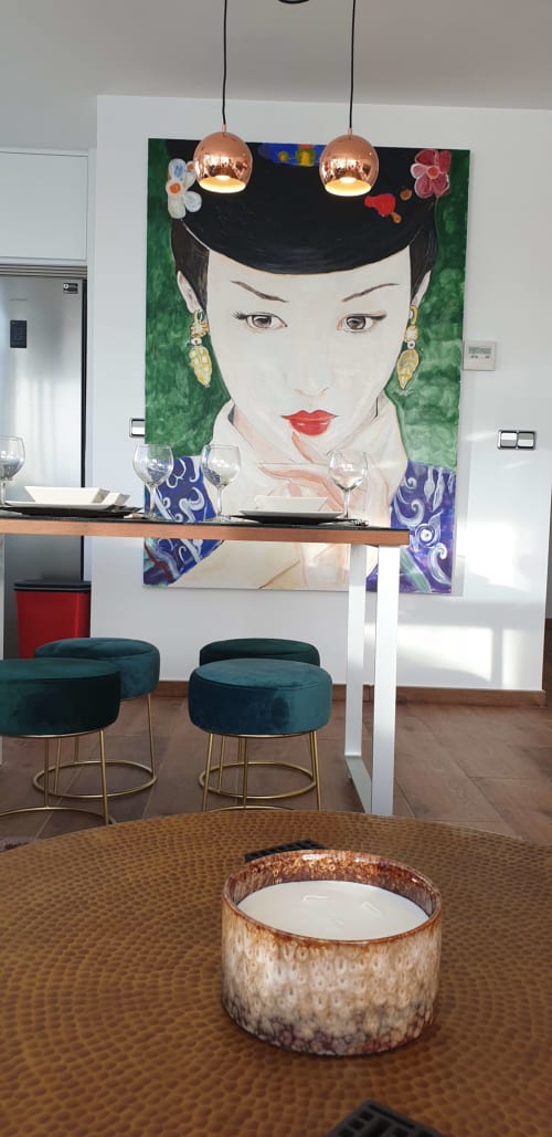 Comedor moderno en Portofino Playa con retrato artístico, lámparas colgantes de cobre, taburetes turquesas y vistas al océano