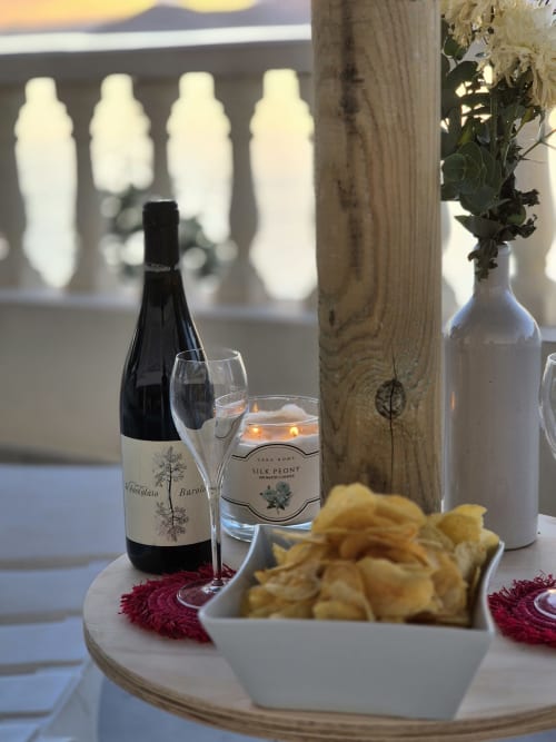Elegante apartamento con vista al mar, botella de vino, copa, vela perfumada, flores blancas y aperitivos en Portofino Playa