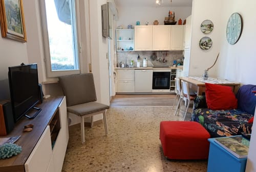 Appartamento Casa Valentina ad Ancona con living open-plan, cucina, sala da pranzo, TV e sedute rosse con giardino