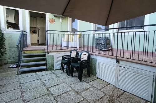 Balcone coperto di Casa Valentina, Ancona con sedute, ringhiera in metallo e vista sul giardino