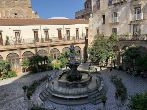 Cortile del Mappamondi BnB a Venezia con fontana centrale, edifici storici e loggiato con archi