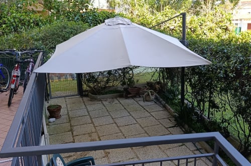 Patio ombreggiato con ombrellone grigio e zona lounge a Casa Valentina, Ancona