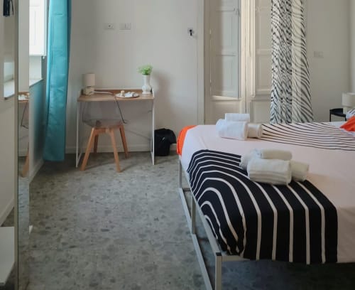 Camera da letto moderna a Venezia con decoro a righe, asciugamani bianchi e scrivania minimalista presso Mappamondi