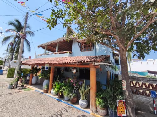Colorida cabaña frente al mar con entrada naranja y nivel superior blanco en Casa Punta Perula, Jalisco, México