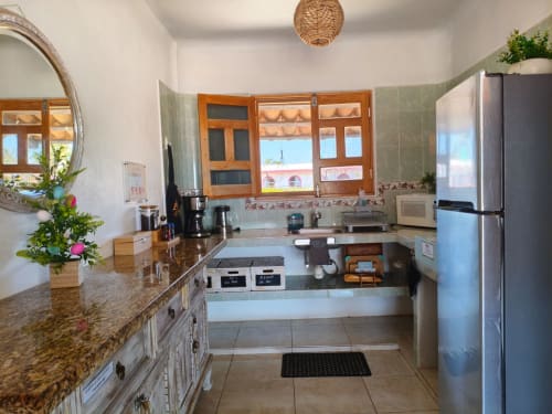 Cocina moderna con encimeras de granito, electrodomésticos de acero inoxidable y vistas al océano en Casa Punta Perula Boutique Hotel