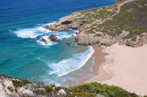 Pristine sandy beach cove with turquoise waters and rocky cliffs near Canha, Portugal