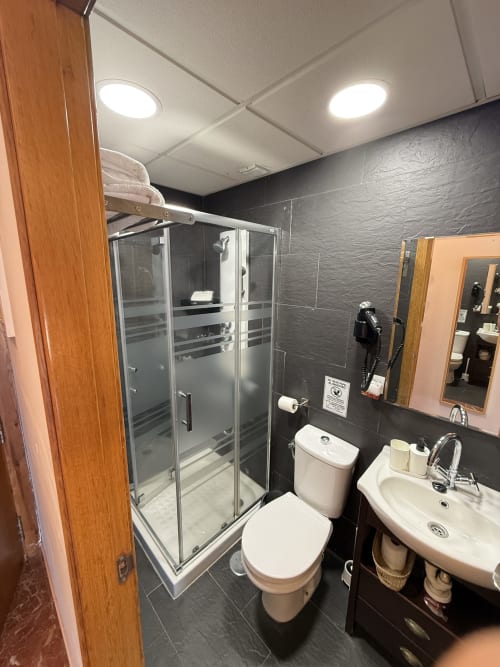 Baño moderno con cabina de ducha, inodoro y lavamanos en Apartamentos A la Orilla del Mar, Matalascañas