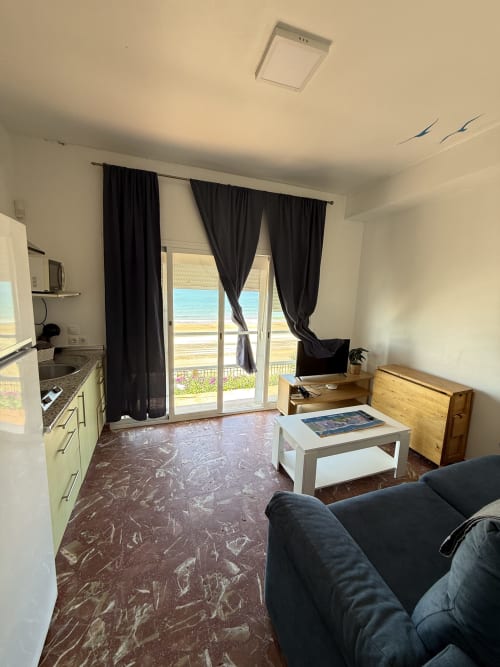 Estudio en primera línea de playa en Matalascañas con vistas al mar, cocina americana, sofá y terraza amueblada