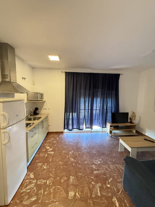 Cocina y sala de estar de estudio moderno con cortinas de vista al mar en Apartamentos A la Orilla del Mar, Matalascañas