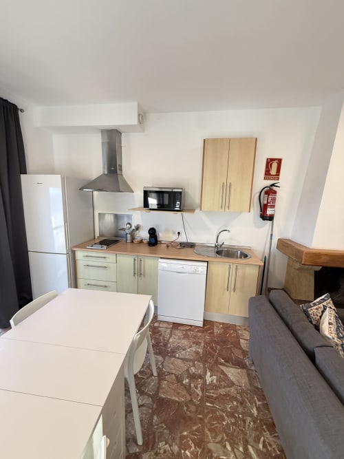 Sala-cocina moderna en apartamento de Matalascañas con mesa de comedor, cocina equipada y zona de estar