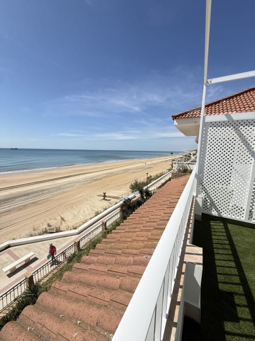 Vista de terraza frente al mar en Apartamentos A la Orilla del Mar, Matalascañas, con playa de arena y horizonte oceánico