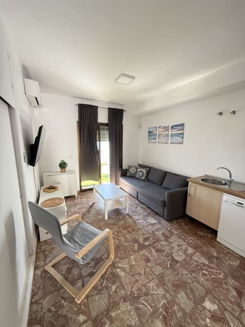 Moderno estudio en Matalascañas con vistas al mar, salón, cocina americana, sofá y acceso a terraza