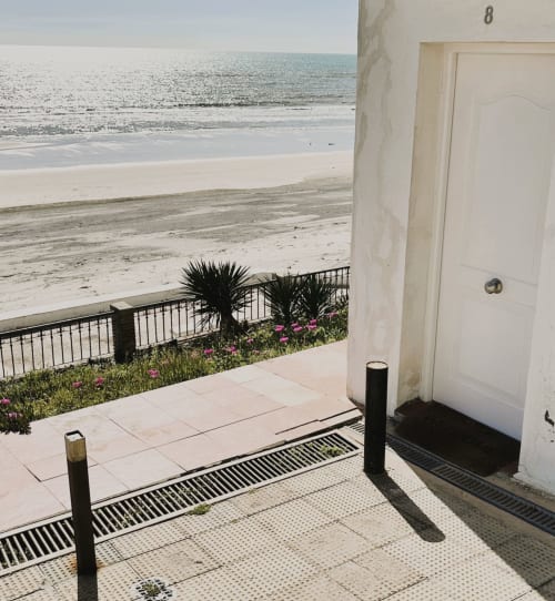 Entrada del Apartamento 8 con vista al mar, patio privado, plantas de palmera y acceso a la playa en Matalascañas