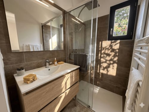 Salle de bain moderne à La villa Métisse à Canet-en-Roussillon avec vasque, douche vitrée et lumière naturelle