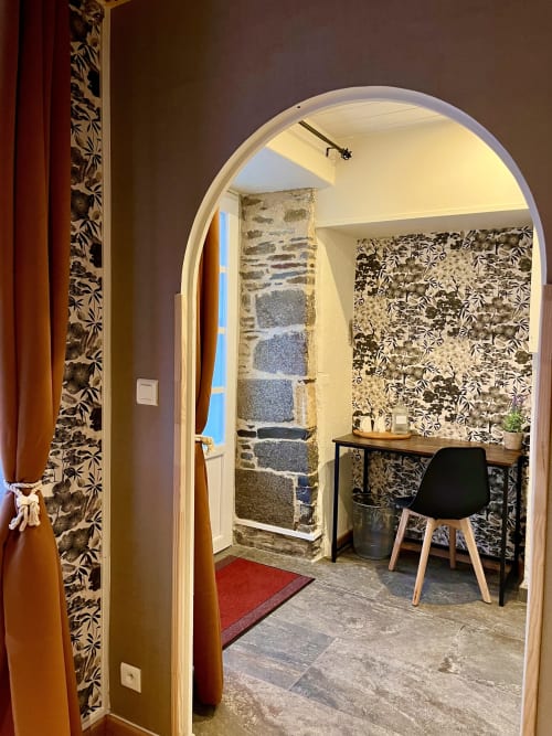 Portail arqué donnant accès à la chambre d'hôtes moderne du Manoir Des Haies, avec papier peint floral, bureau et escalier en pierre