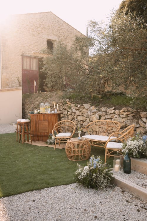Coin de détente rustique au Mas de la Vernède à Aramon avec fauteuils en osier et murs en pierre