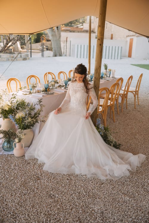 Mariée en robe de dentelle blanche sous tente de toile, lieu de réception Le Mas de la Vernède, Aramon