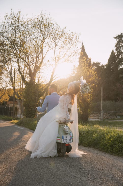 Mariés sur un scooter vintage au Mas de la Vernède, lieu de réception à Aramon, au coucher du soleil