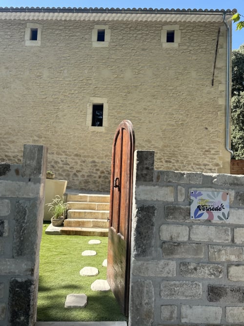 Stone cottage entrance at Le Mas de la Vernède in Aramon with wooden door and pathway