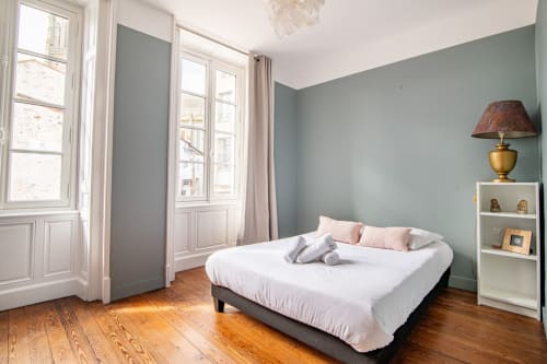 Chambre spacieuse à Bise de la Jouvence près du Puy du Fou avec murs vert sauge, parquet et vue sur la ville depuis les grandes