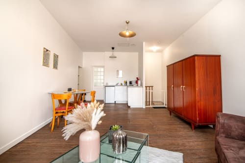 Bright apartment living room with wooden floors, dining area, kitchenette, and red wardrobe near Puy du Fou
