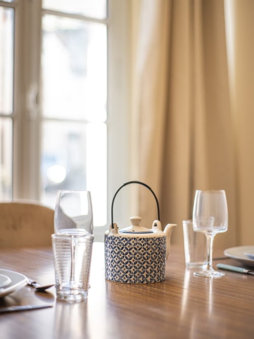 Élégante table dressée à la Bise de la Jouvence avec théière, verres et couverts surplombant Saint Laurent sur