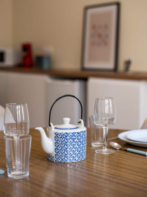 Table élégante dressée avec théière bleu et blanc, verres et couverts à la Bise de la Jouvence