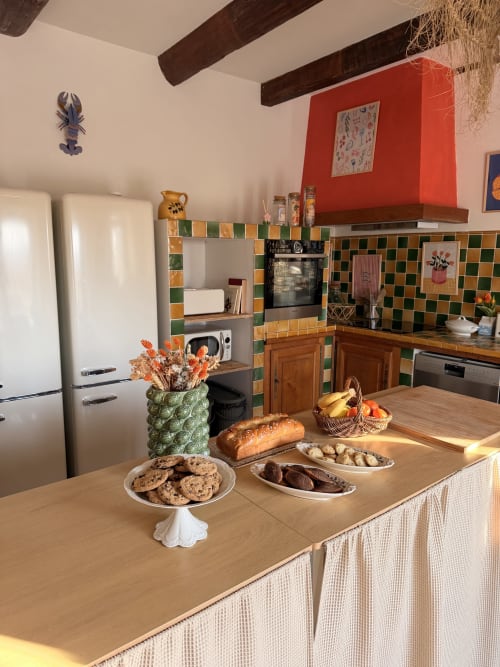 Colorful kitchen in L'Écrin room at Le Mas de la Vernède, Aramon, with fresh bread, pastries and fruit on counter