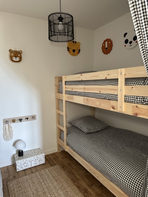 Children's bedroom with wooden bunk beds, black gingham bedding, and playful animal wall decorations at Le Mas de la Vernède