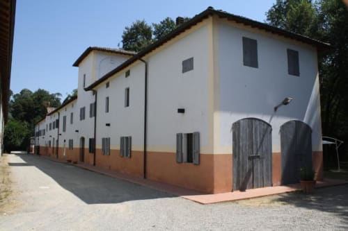 Agriturismo Aggazzotti, caratteristico nella campagna italiana con facciata bianca e terracotta, porte in legno e persiane verdi