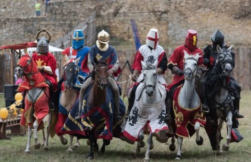 Chevaliers médiévaux à cheval en armure complète se produisant au Pas de Moineau, un gîte à Lhuis, France.