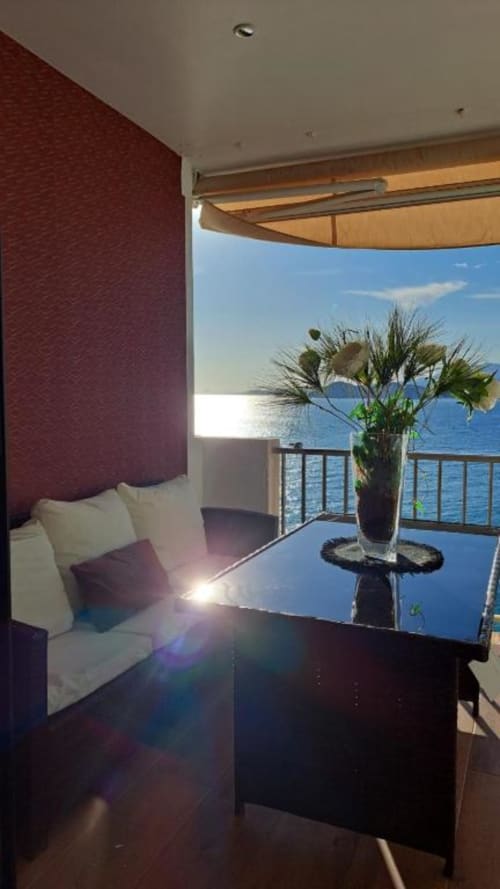 Suite de lujo frente al mar en Portofino Playa con terraza vista al mar, mobiliario moderno y arreglo floral en Benidorm