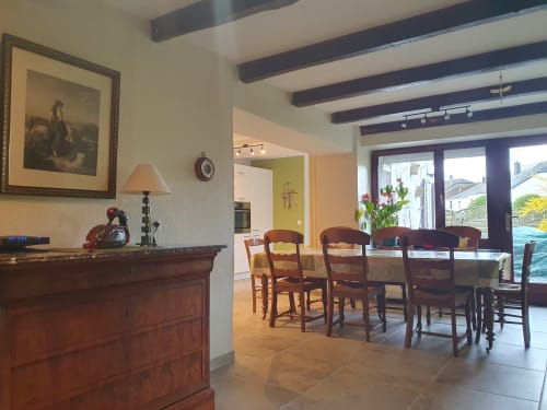 Élégante salle à manger de la maison d'hôtes Sur La Rive Vierre à Chiny, Belgique, avec poutres en bois et portes-fenêtres