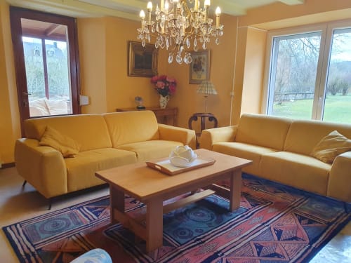 Elegant yellow living room with two sofas, crystal chandelier, and fireplace at Sur La Rive Vierre B&B in Chiny, Belgium