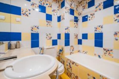 Casa de banho colorida com azulejos em mosaico azul e amarelo no Apartamento Marina Prestige, Atlantic Places, Albufeira