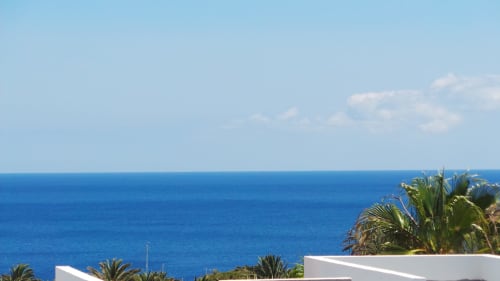 Panoramic sea view from Villa 7 at Villas del Mar, Puerto Calero with palm trees and blue ocean horizon